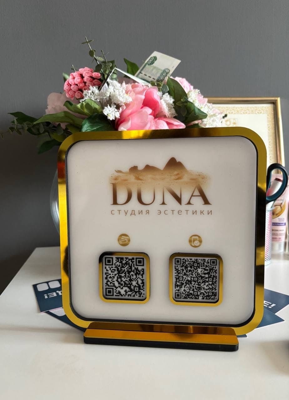 Настольная акриловая табличка с золотой рамкой и QR-кодами для студии эстетики DUNA