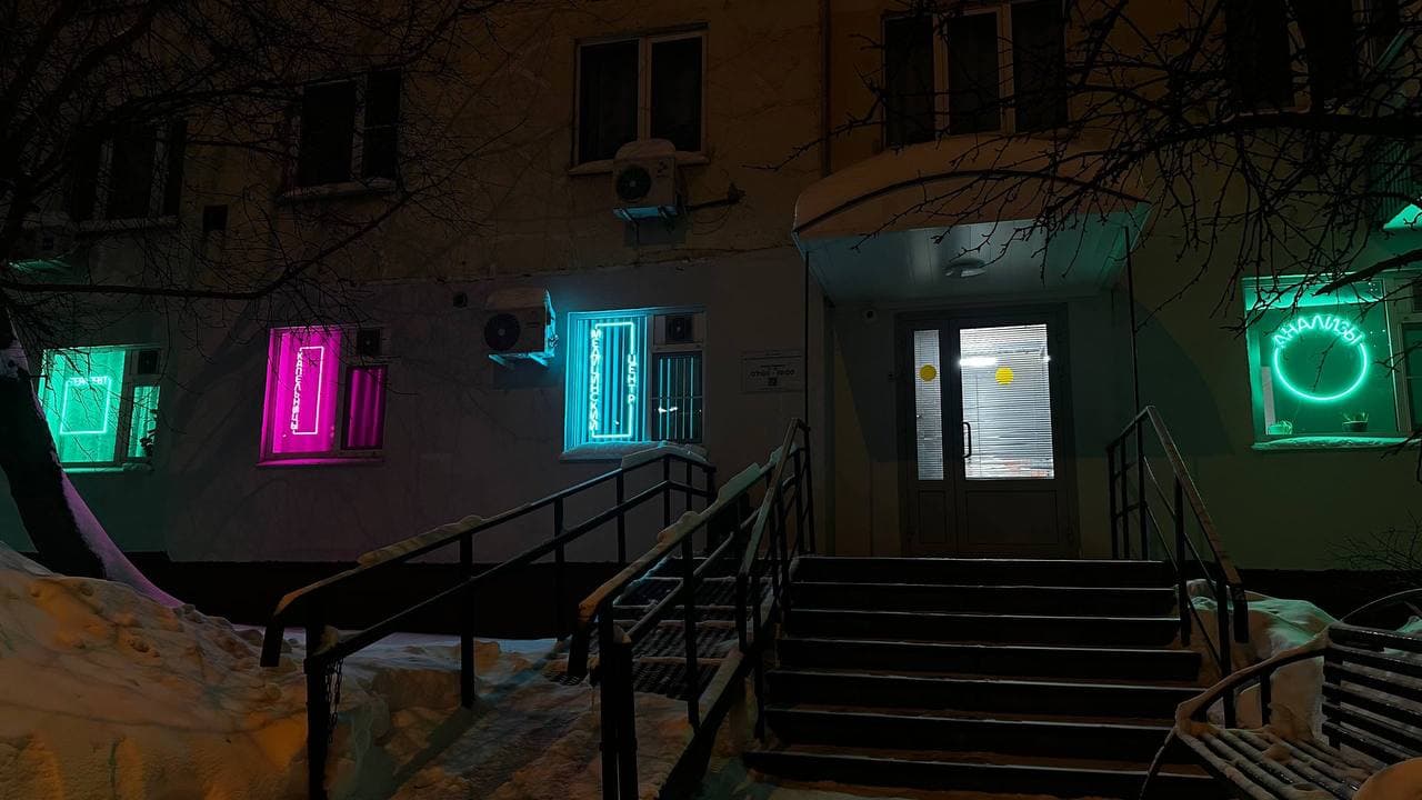 Разноцветные неоновые вывески в окнах медицинского центра в ночное время